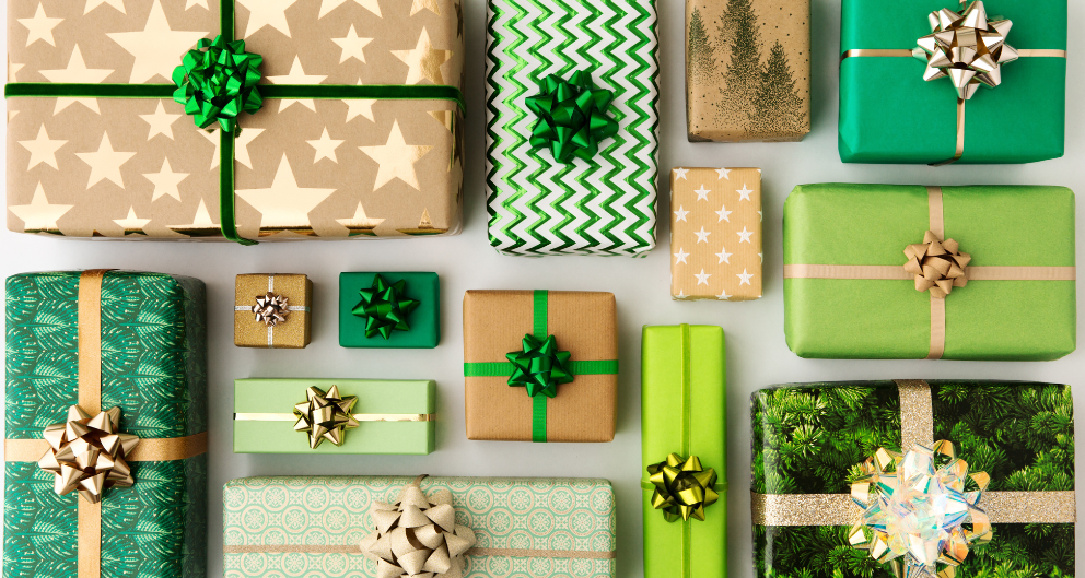 An overhead images of many boxed gifts, wrapped in shades of green and gold